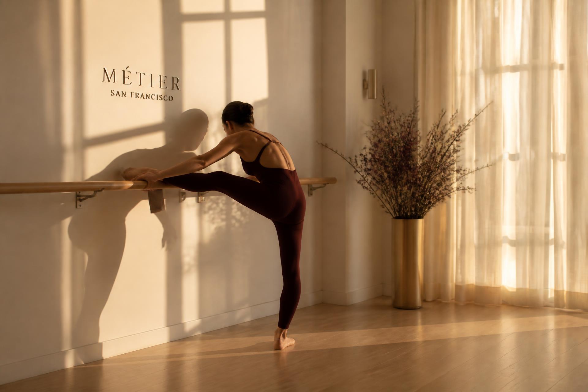 Sunlit boutique barre studio with a ballet barre and warm ivory walls
